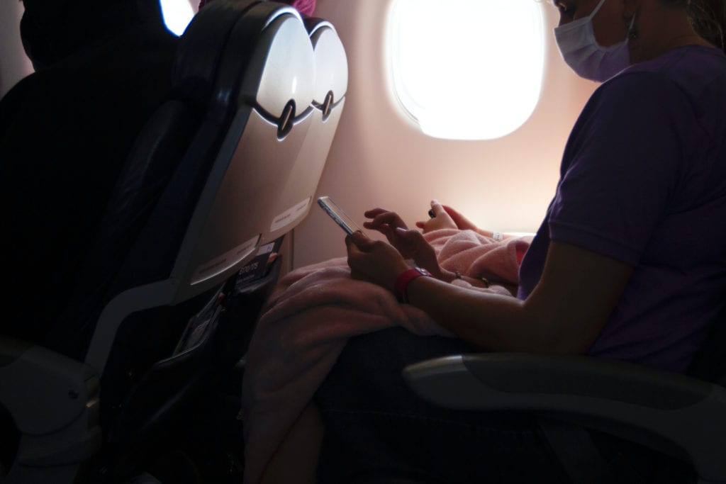 Passenger with mask on sitting on an airplane