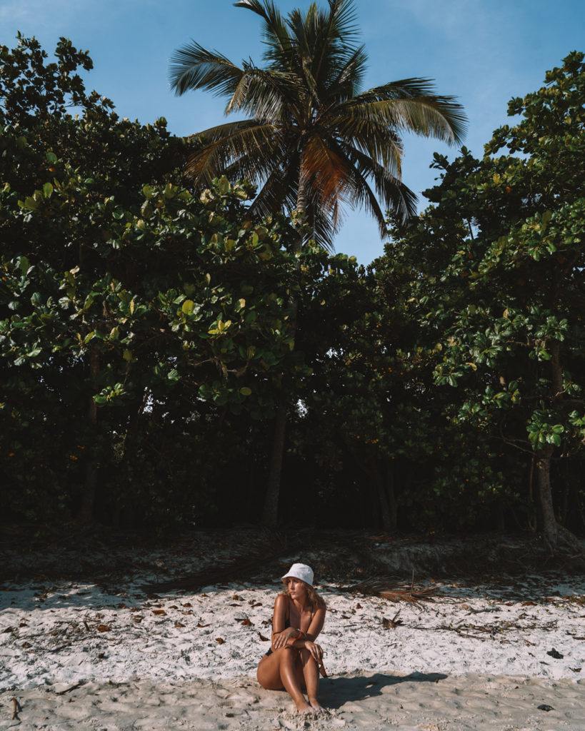 Girl sitting underneath a palm tree Ilga Grande Rio de Janeiro Brazil