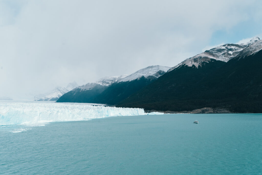 a boat tour approaches the walls of Perito Moreno glacier in Argentina, southern Patagonia