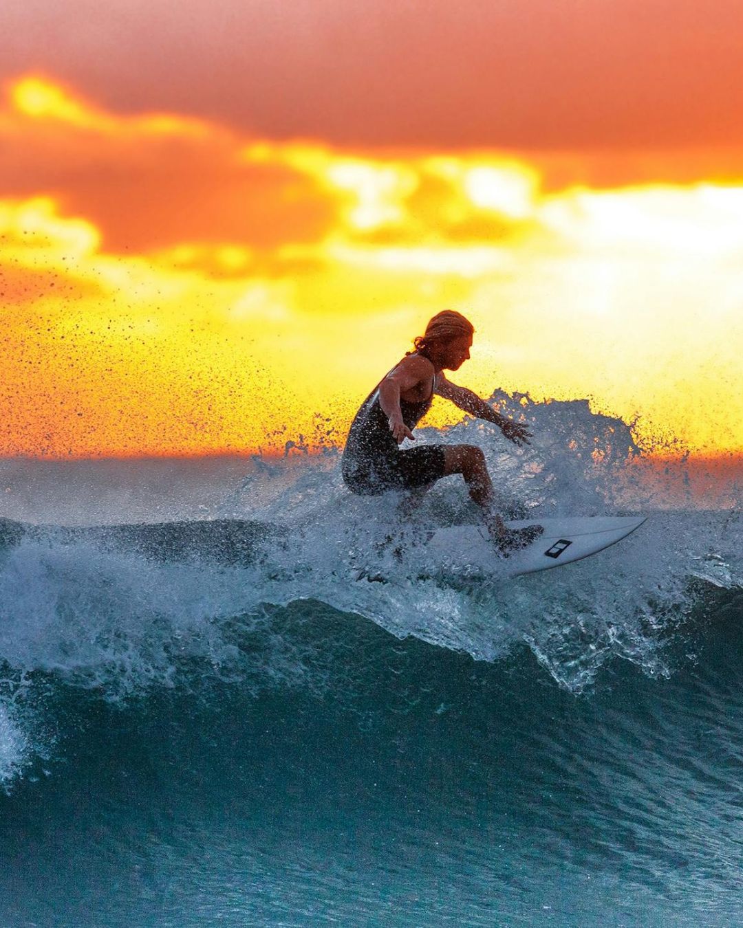 Man surfing with sunset behind